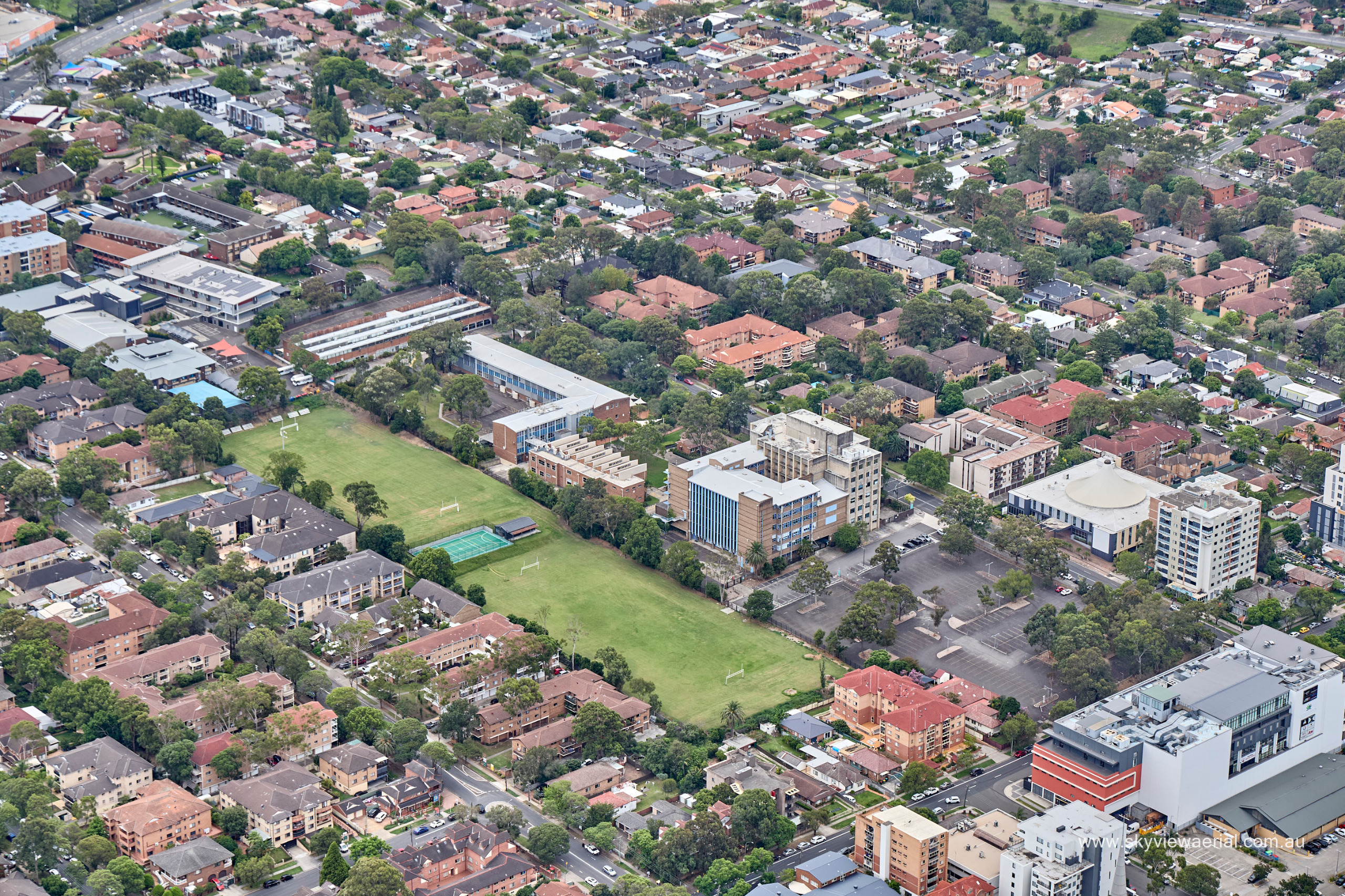 Aerial view of a city block with buildings and playing fields