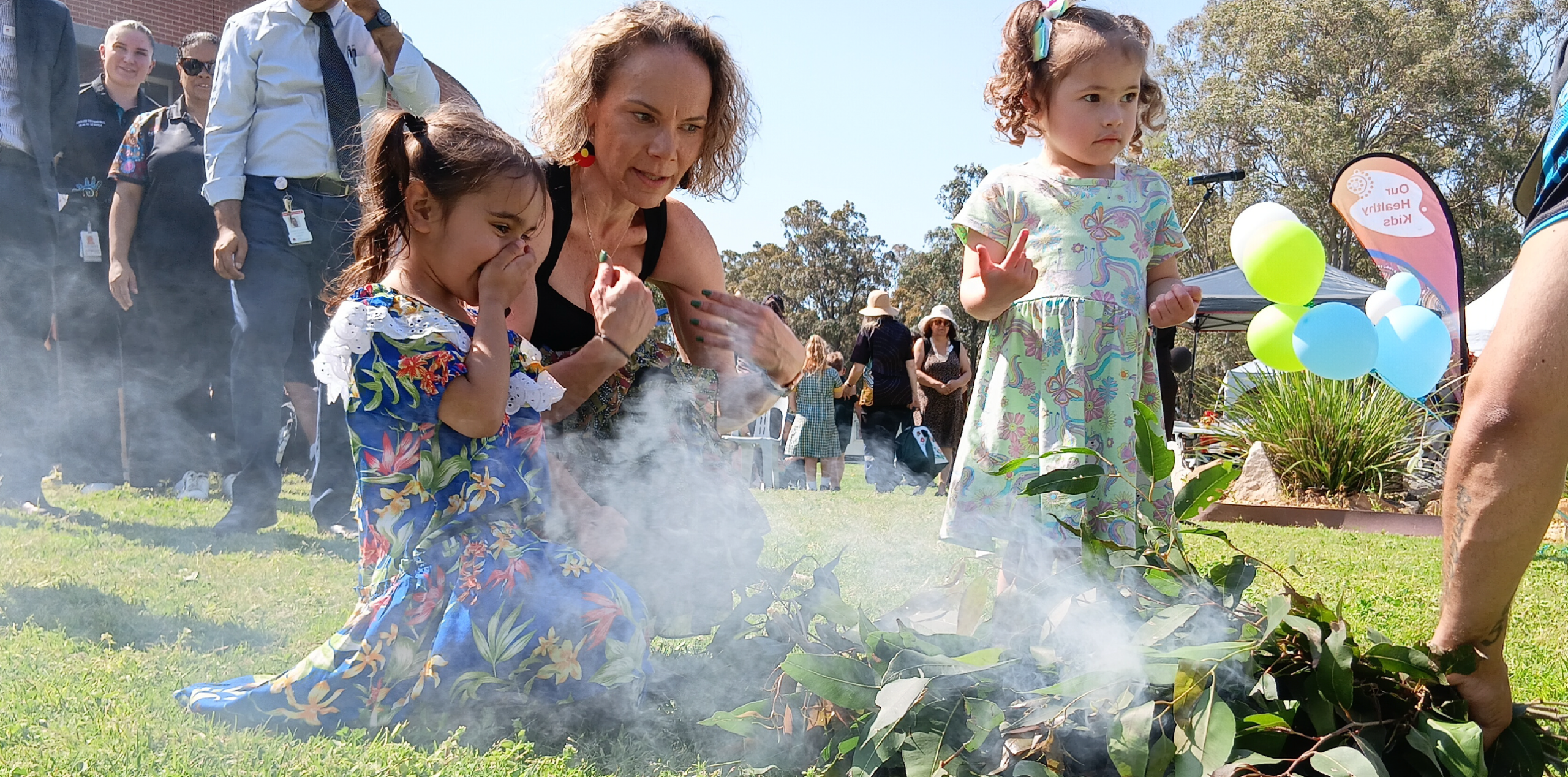 A woman with 2 children at an Aboriginal smoking ceremony